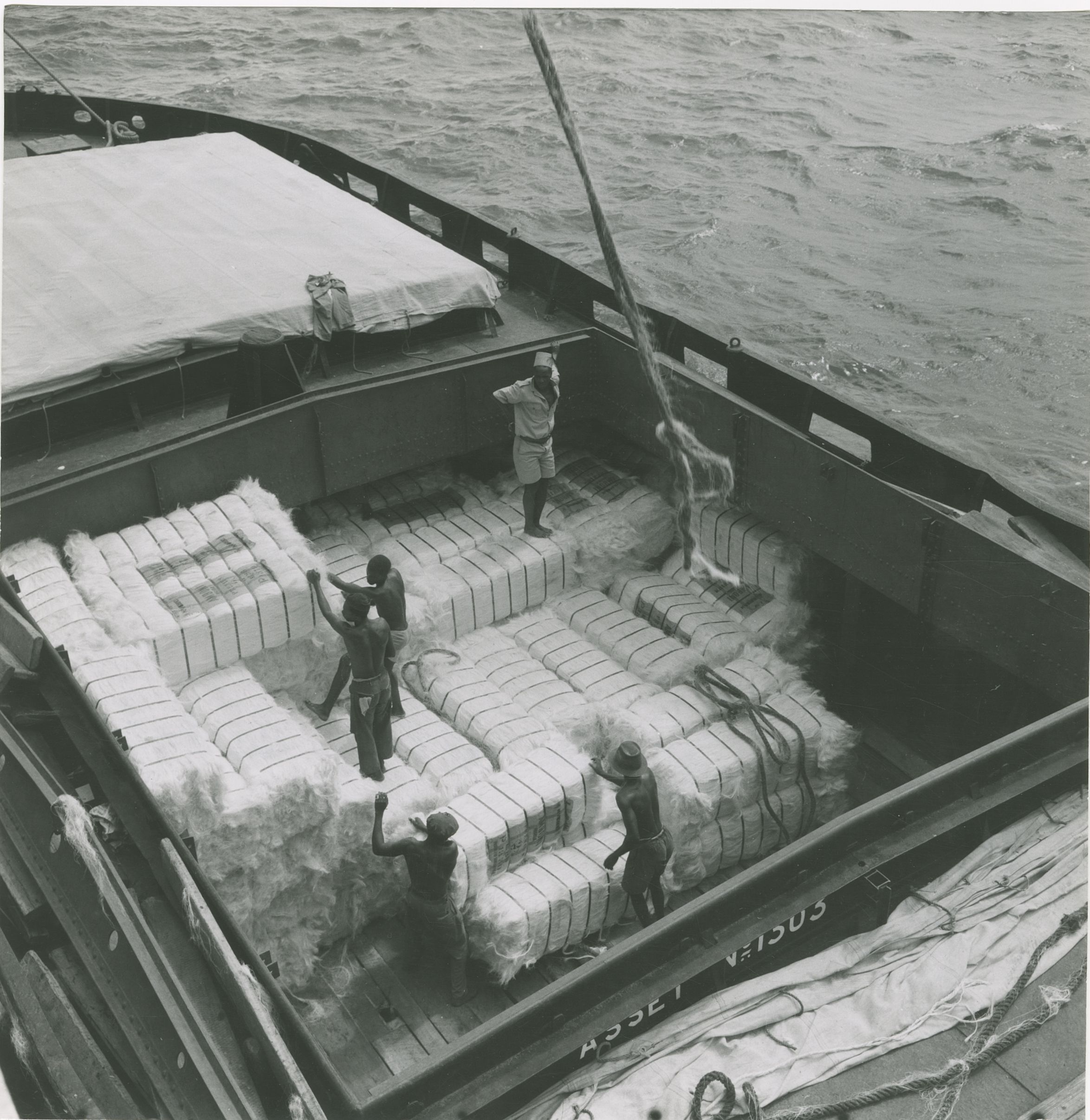 Historical 1959 photograph of a cargo of sisal fibre bales being loaded onto a ship at the Port of Tanga, Tanzania, during the industry's peak export era -- useful for historical-context sections, not current operations.